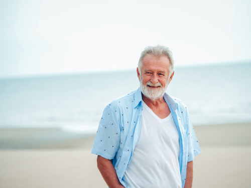 Older man smiling outside after macular edema treatment